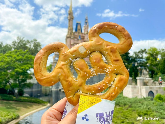 um pretzel com a cara do mickey em frente ao castelo da cinderela no Magic Kingdom